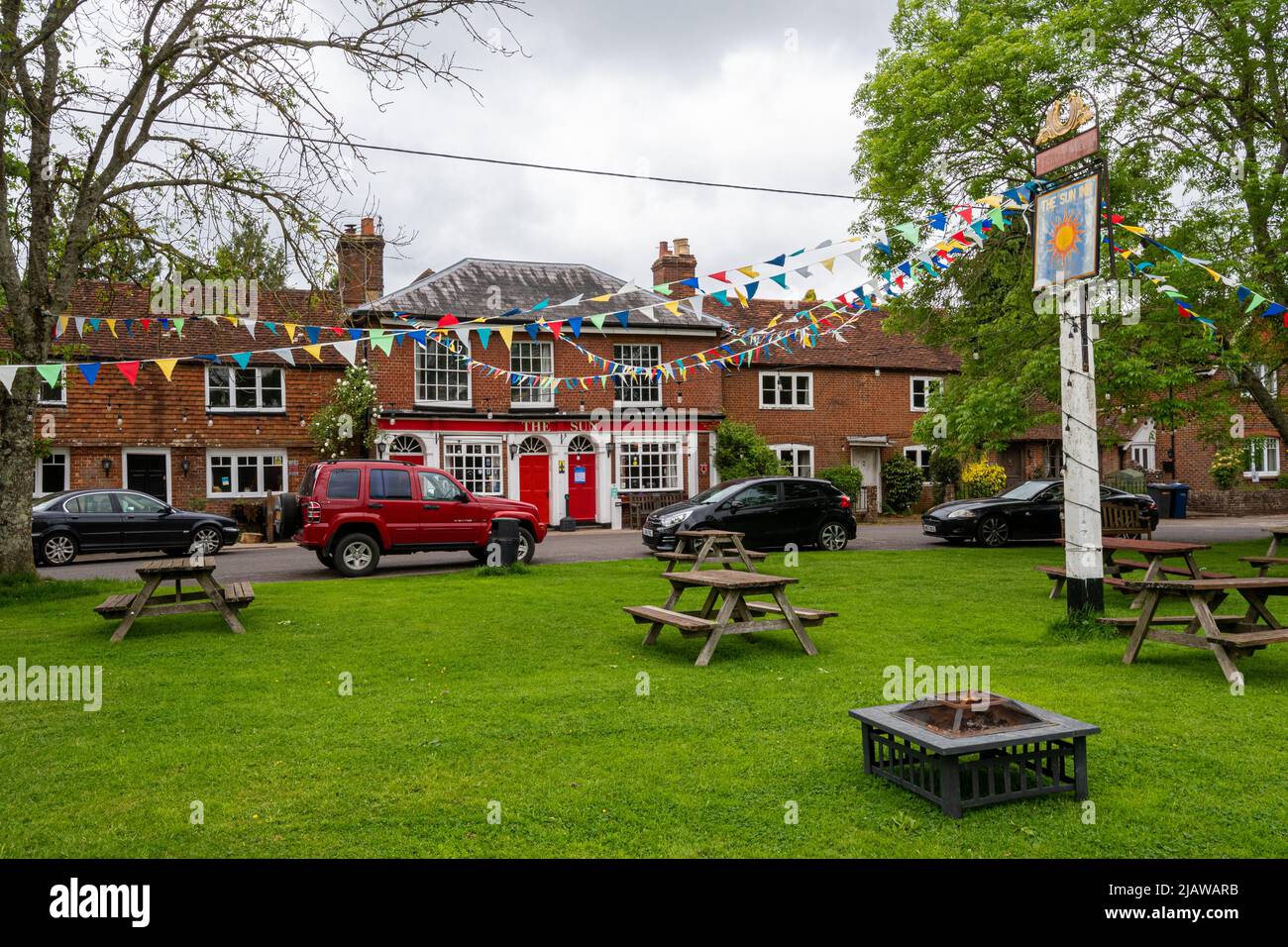 Il Sun Inn nel villaggio di Dunsfred, Surrey, Inghilterra, Regno Unito, con i grappoli colorati Foto Stock