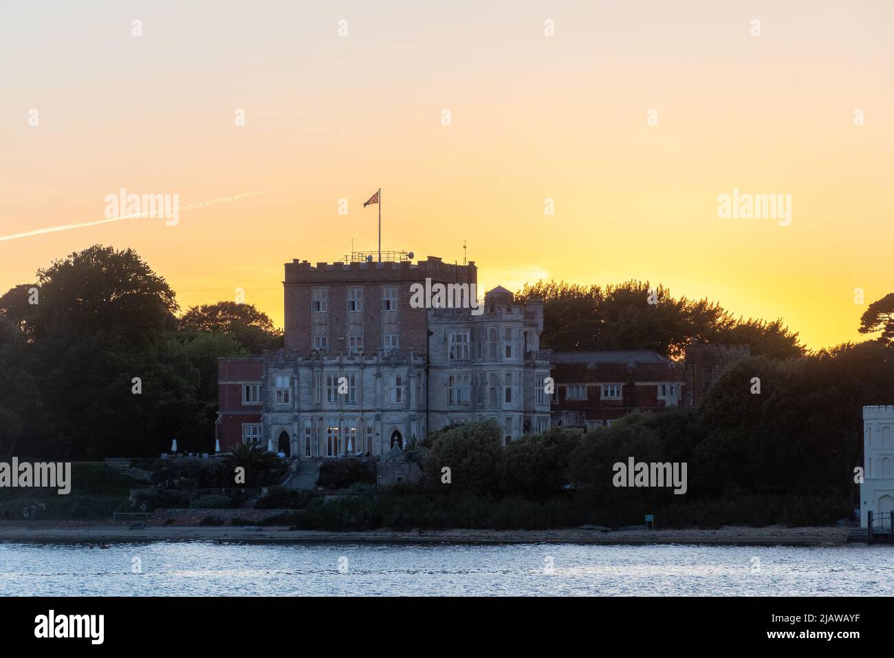 Castello di Brownsea al tramonto sull'Isola di Brownsea a Poole Harbour, Dorset, Inghilterra, Regno Unito. Vista dal mare. Foto Stock