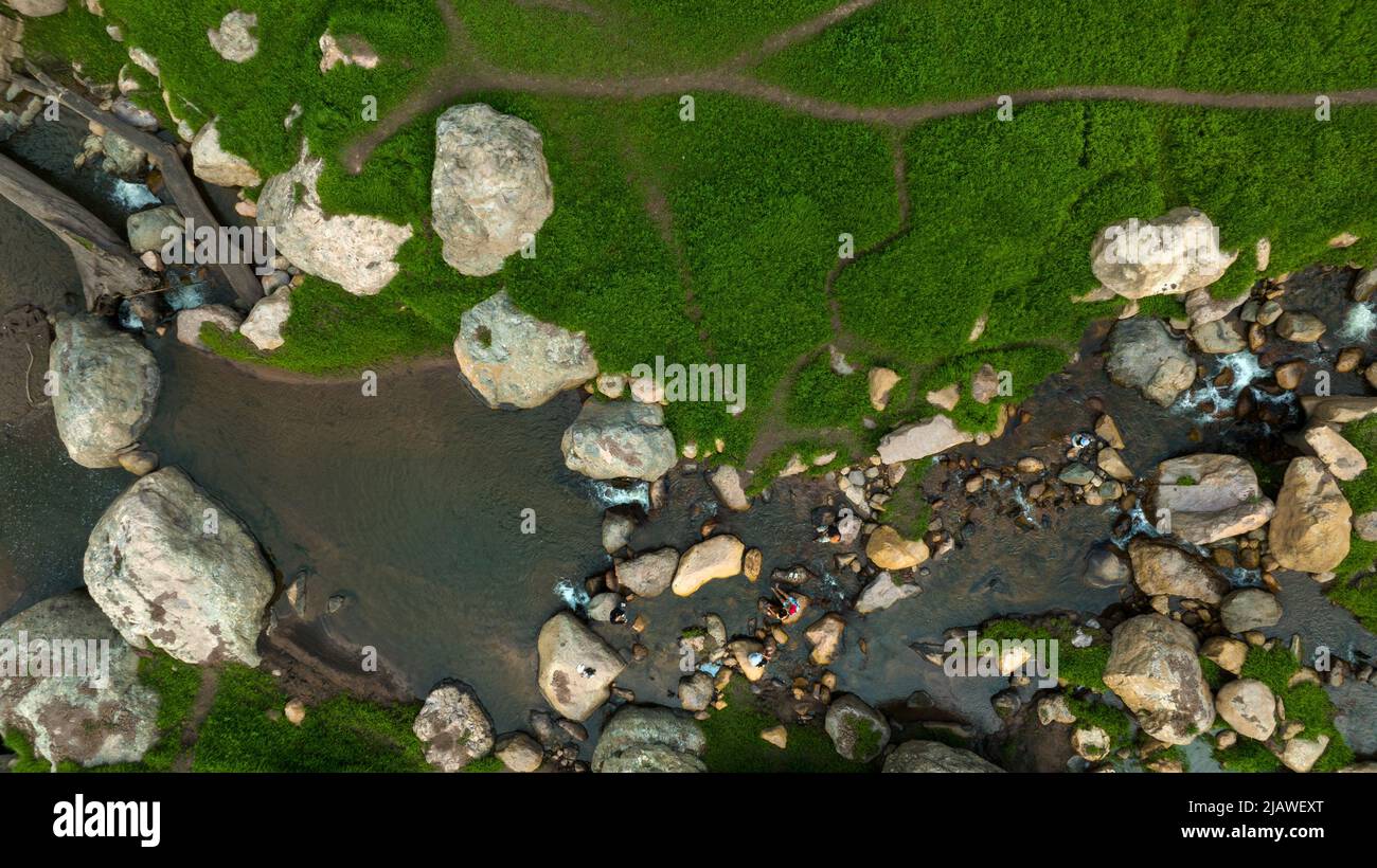 Vista aerea del bel ruscello naturale e campo verde di erba nella foresta selvaggia concetto di montagna viaggio e relax in vacanza. Foto Stock