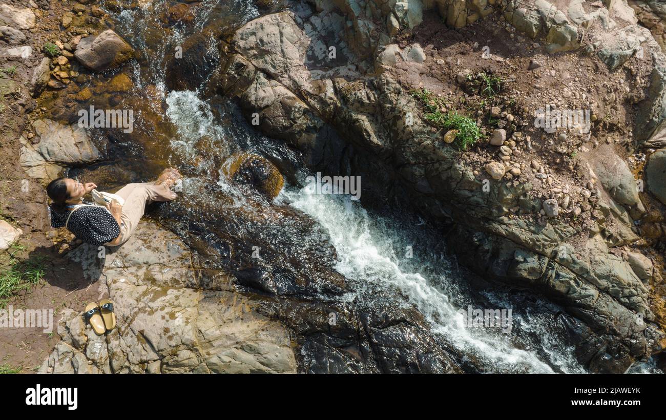 Vista aerea della Donna rilassante con bel torrente naturale il concetto di montagna foresta selvaggia viaggiare e rilassarsi in vacanza. Foto Stock