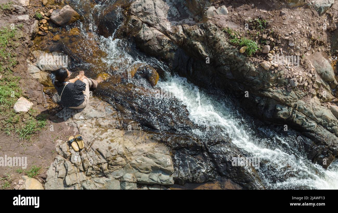 Vista aerea della Donna rilassante con bel torrente naturale il concetto di montagna foresta selvaggia viaggiare e rilassarsi in vacanza. Foto Stock