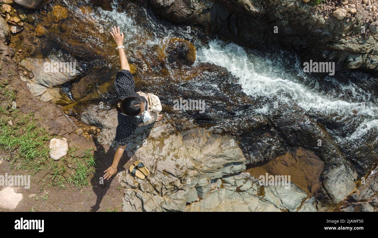 Vista aerea della Donna rilassante con bel torrente naturale il concetto di montagna foresta selvaggia viaggiare e rilassarsi in vacanza. Foto Stock