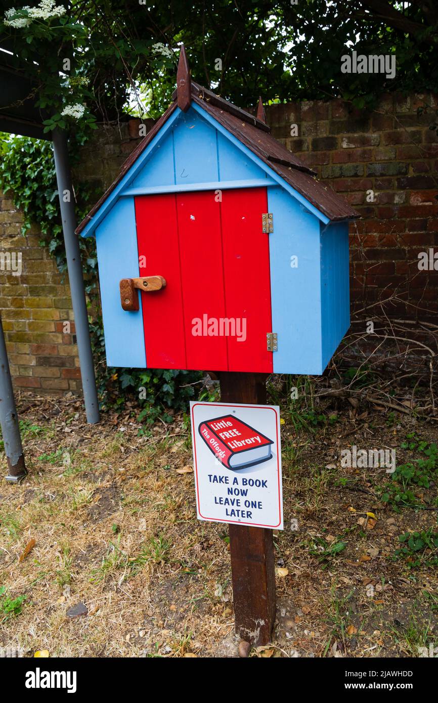 La piccola biblioteca libera di Offords, scatola di scambio del libro su posta. Blu con porta rossa. Offord Cluny, Cambridgeshire, Inghilterra Foto Stock