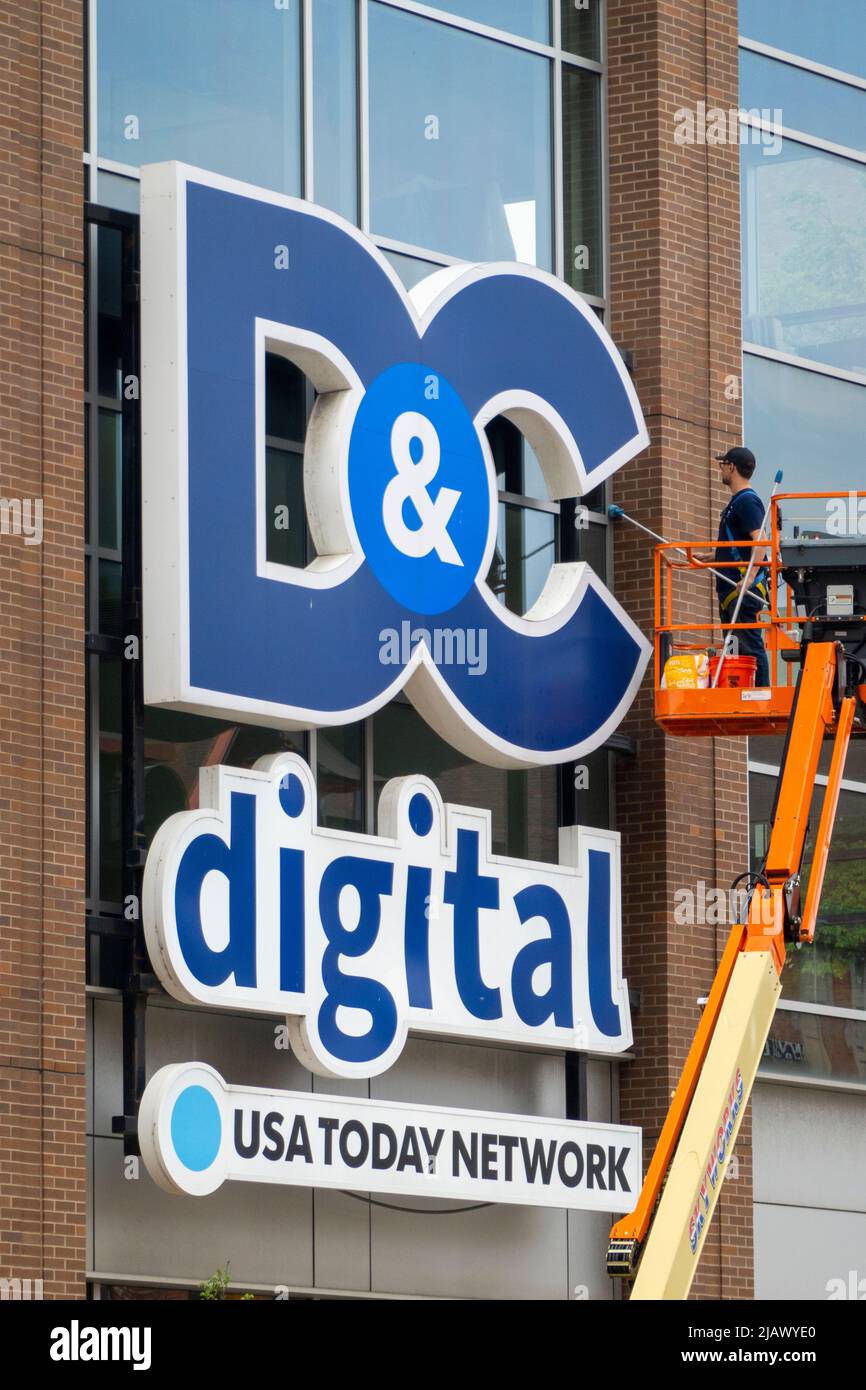 Uomo lavando finestre sul D & C Digital Company edificio a Rochester NY Foto Stock