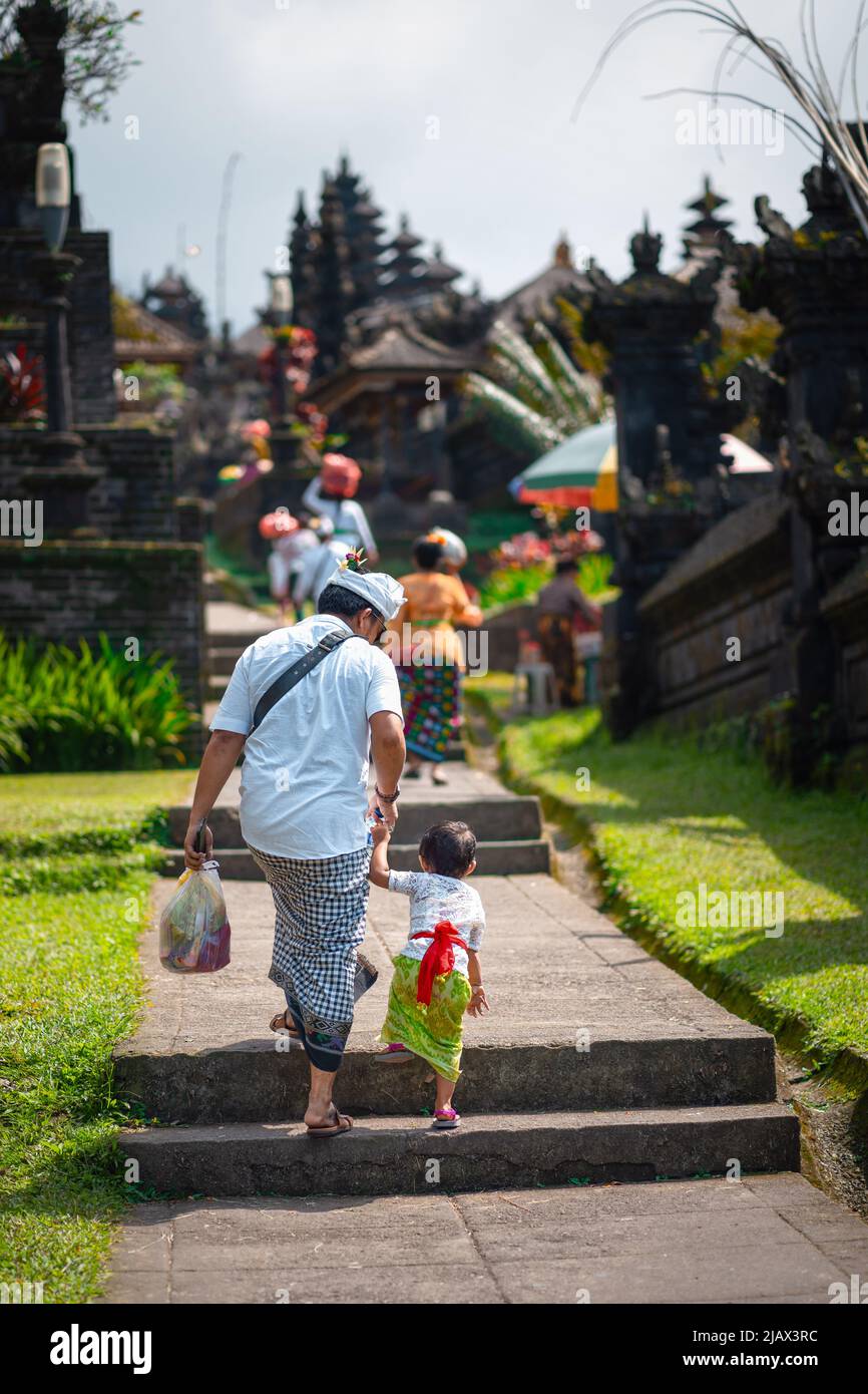 Padre e figlio tengono le mani e salgono le scale. Cultura indonesiana. isola di Bali. Foto Stock