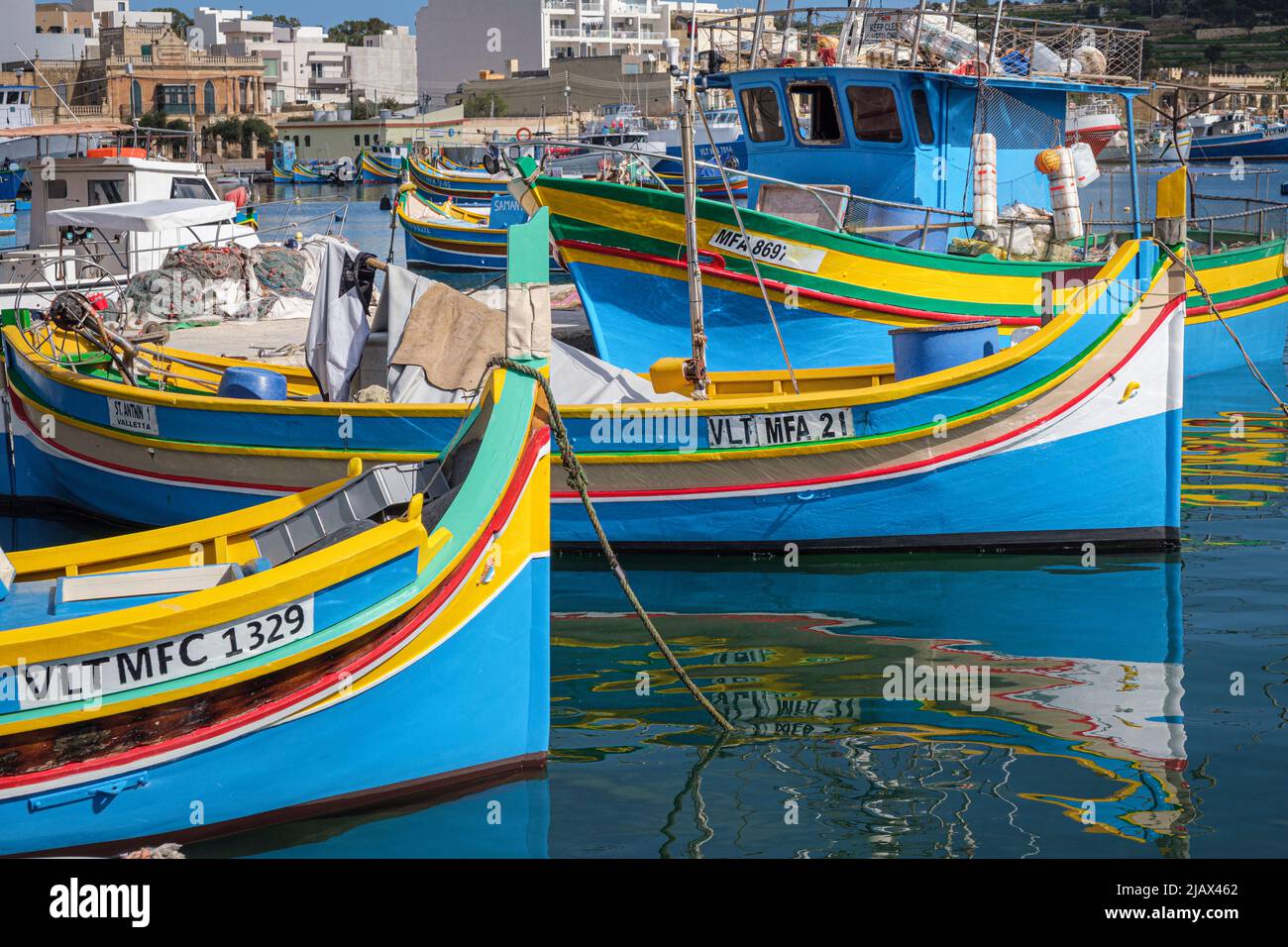 Tradizionali barche da pesca dipinte di colore conosciute come luzzus nel porto di Marsaxlokk, Malta Foto Stock