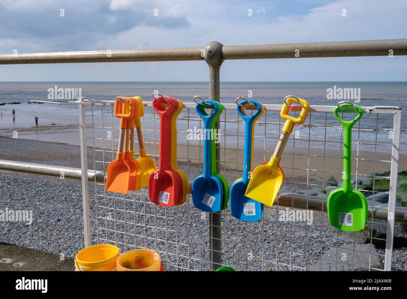 Secchi di plastica colorati e picche in vendita sul lungomare di Sheringham, Norfolk, Inghilterra Foto Stock