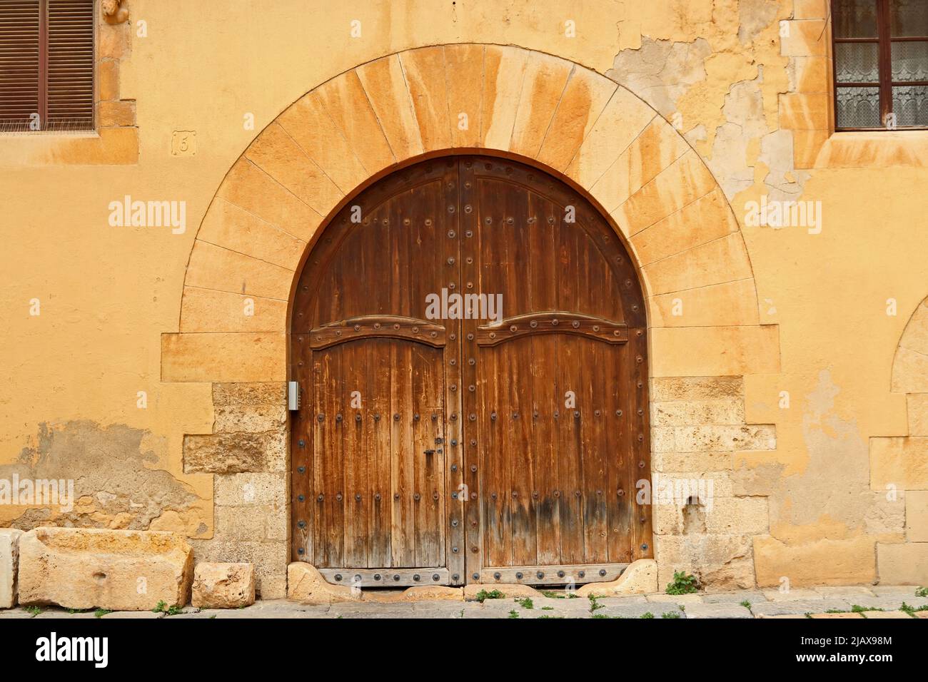 Antica arcata in pietra con porte in legno usurate, Tarragona Foto Stock