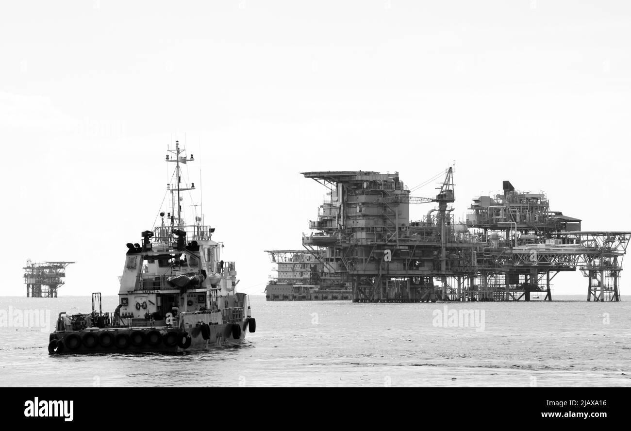 Piattaforme petrolifere con barca di rifornimento per il trasporto di persone o materiali a piattaforme vicine, South China Sea, Malesia Foto Stock