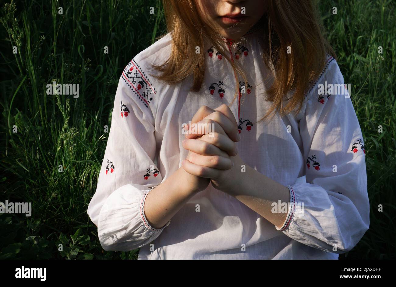 Una ragazza in camicia ricamata Ucraina sta pregando Foto Stock