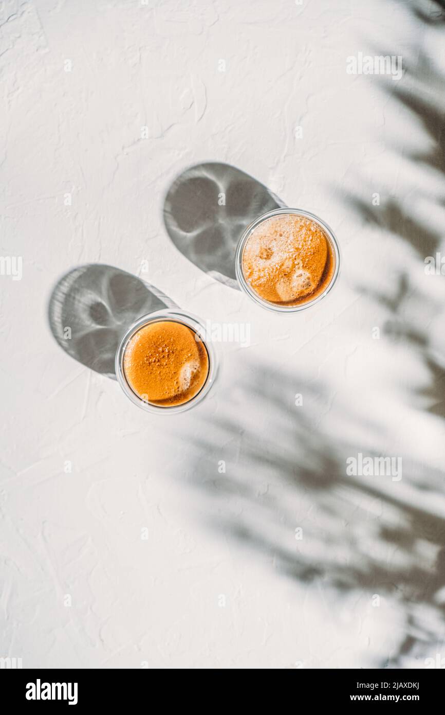 Due tazze di caffè con ricca crema e belle ombre sul tavolo Foto Stock