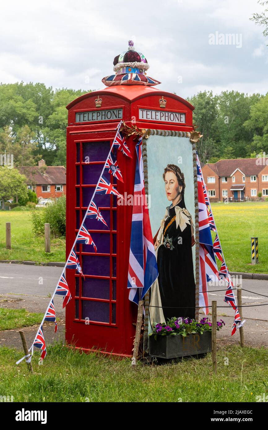 Box telefonico rosso decorato per il Queens Platinum Jubilee nel villaggio di Surrey di Compton, Inghilterra, Regno Unito Foto Stock
