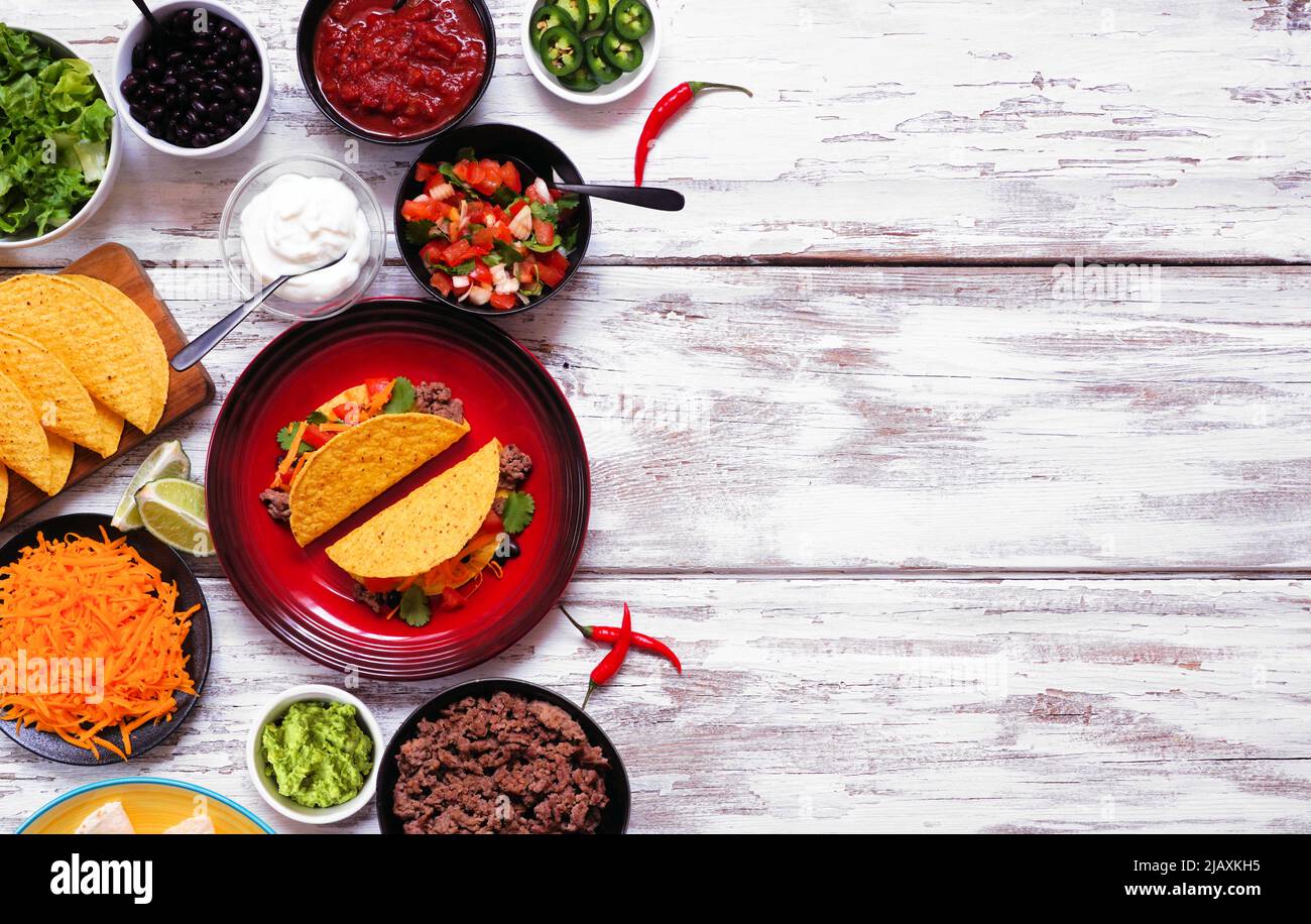 Bordo laterale del Taco Bar con ingredienti assortiti. Vista dall'alto su un rustico sfondo di legno bianco. Buffet di cucina messicana. Spazio di copia. Foto Stock