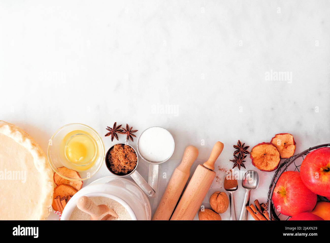 Far cadere il bordo inferiore della cottura con gli ingredienti della torta di mele. Vista dall'alto su sfondo di marmo bianco con spazio per la copia. Foto Stock