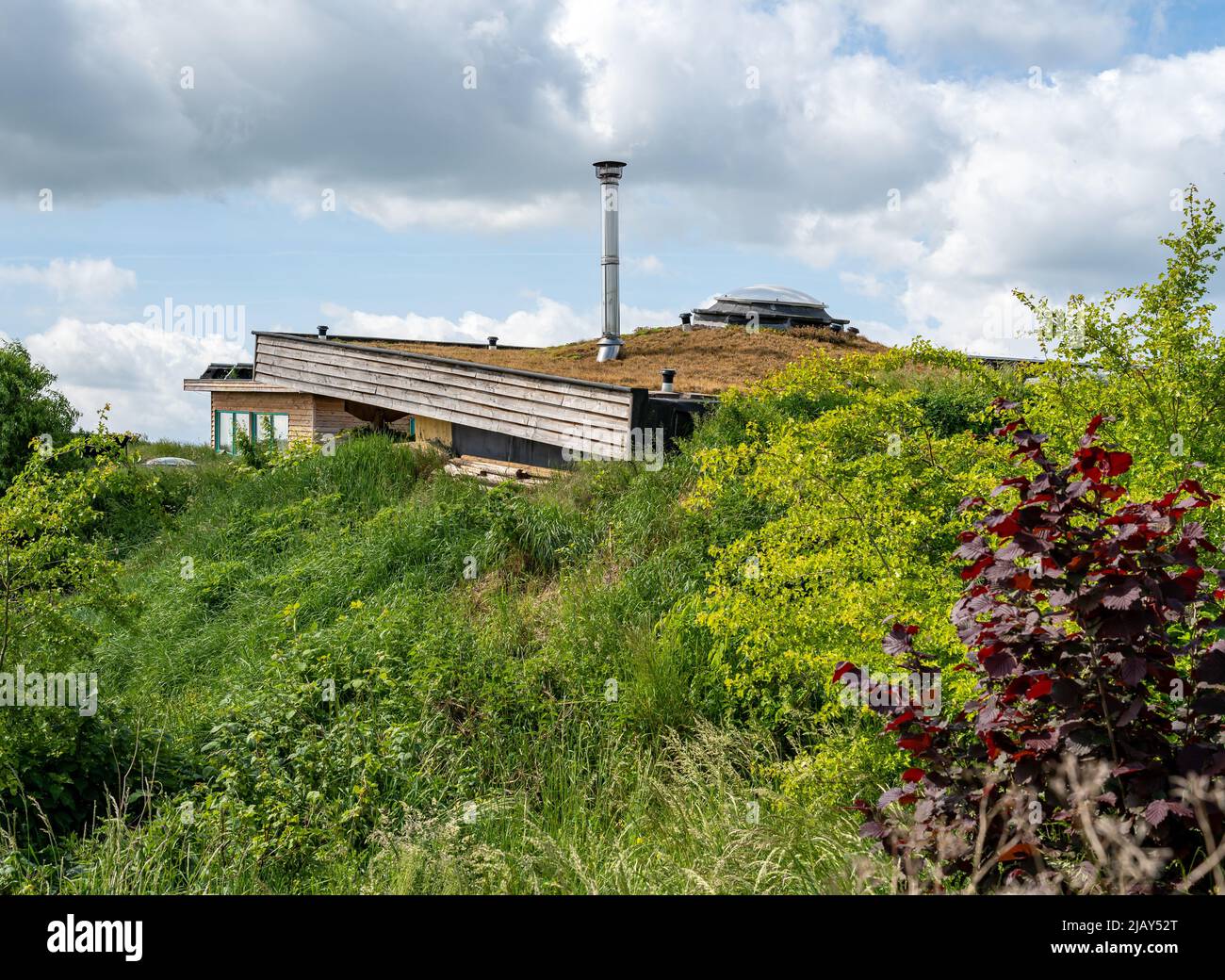 Tetto di casa di terra auto-sufficiente moderna con terreno contro le pareti Foto Stock