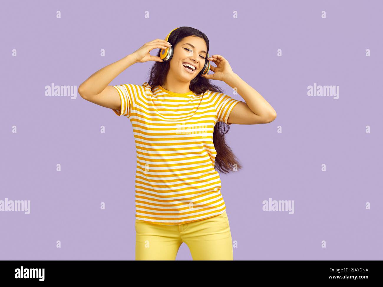 Divertente etnia ragazza ascoltare la musica in auricolari wireless Foto Stock