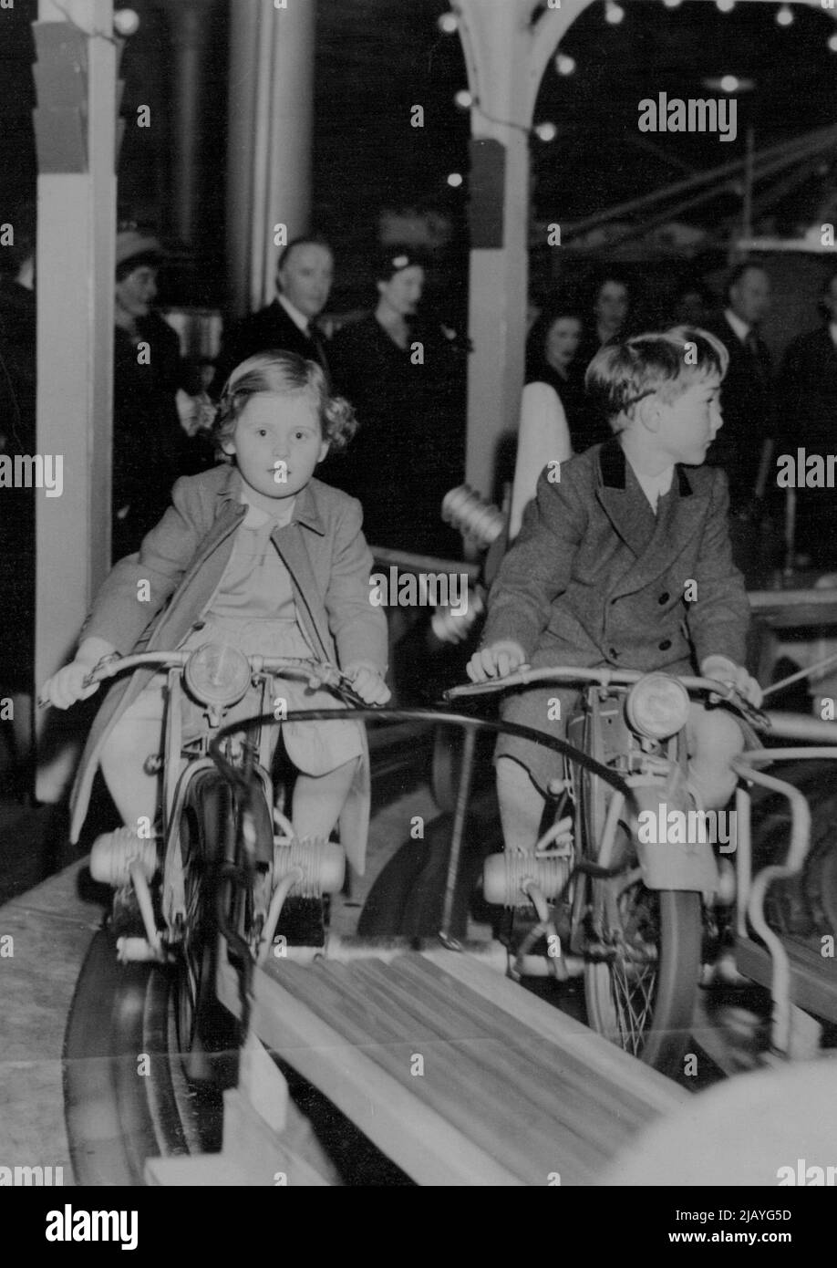 Joy-Ride per un Principe -- il Principe William, figlio maggiore del Duca di Gloucester, corre con un amico sulla rotonda in miniatura al circo olimpico e al funfair che ha visitato con suo fratello, il Principe Richard. Febbraio 04, 1948. Foto Stock