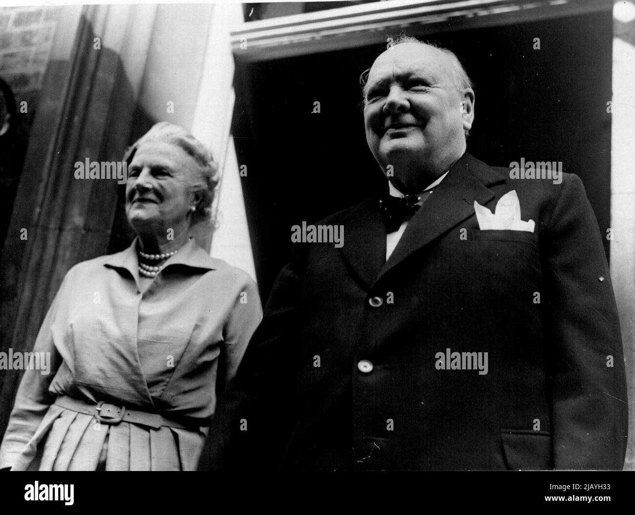Churchills a Downing Street per il ricevimento dopo Eden Wedding: Il primo Ministro Winston Churchill sorride sulla folla fuori dal numero 10, Downing Street, come con la Signora Churchill arriva alla sua residenza dopo il matrimonio alla Sala Caxton del Ministro degli Esteri Anthony Eden e la Signora Clarissa Spencer-Churchill. Miss Churchill è una nipote del Premier. La reception è stata tenuta al numero 10. Agosto 14, 1952. Foto Stock