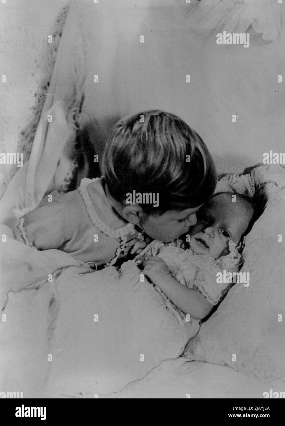 La prima fotografia scattata dai due figli della Principessa Elisabetta e del Duca di Edimburgo. In questo delizioso studio fatto da Cecil Beaton a Clarence House, Londra, il principe Carlo, che avrà due anni a novembre è visto appoggiarsi sopra per baciare il volto del suo mese - vecchia sorella principessa Anne. Il titolo ufficiale dato al nuovo bambino è la principessa Anne Elizabeth Alice Louise di Edimburgo. Maggio 15, 1953. Foto Stock
