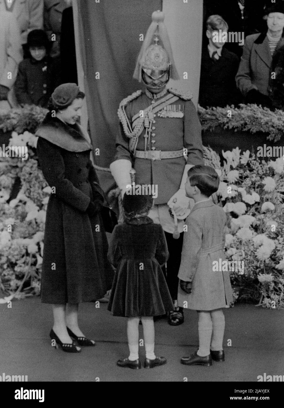 Principessa Mad loro Smile anche il poliziotto di guardie di vita ha dovuto rilassare la dignità militare per unirsi alla Regina e il Principe Carlo in un sorriso a un bambino fremito dalla principessa Anne. Ambientazione per questa piccola scena felice era la stazione di Waterloo, dove la famiglia reale aspettava di dare il benvenuto a casa alla madre regina dalla sua visita in Canada e negli Stati Uniti. Novembre 24, 1954. (Foto di Reuterphoto). Foto Stock