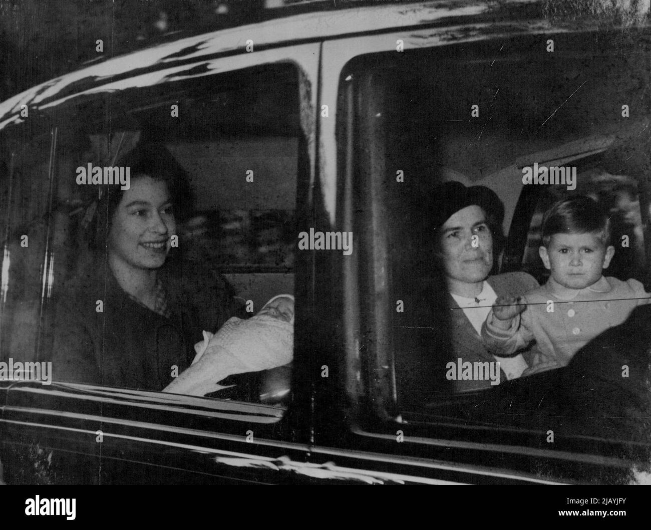 Il principe Charles Waves come Famiglia parte per la principessa Balmoral Elizabeth e il principe Charles (ondeggiando) mentre l'automobile lascia la Clarence House Londra, per la stazione di croce del re stasera. Nurse lightbody regge il Principe Carlo. La principessa Elisabetta detiene la principessa Anne. La principessa Elisabetta e i suoi due figli - il Principe Carlo e la Principessa Anna (nata il 15 agosto) - sono partiti da Londra questa sera (domenica) per unirsi al Re e alla Regina a Balmoral in Scozia. Il viaggio è in treno dalla stazione di King's Cross. La Principessa Elisabetta rimarrà al Balmoral per tre settimane. Si è in aereo per unirsi al Duca di Edimburgo a Malta al Duca Foto Stock
