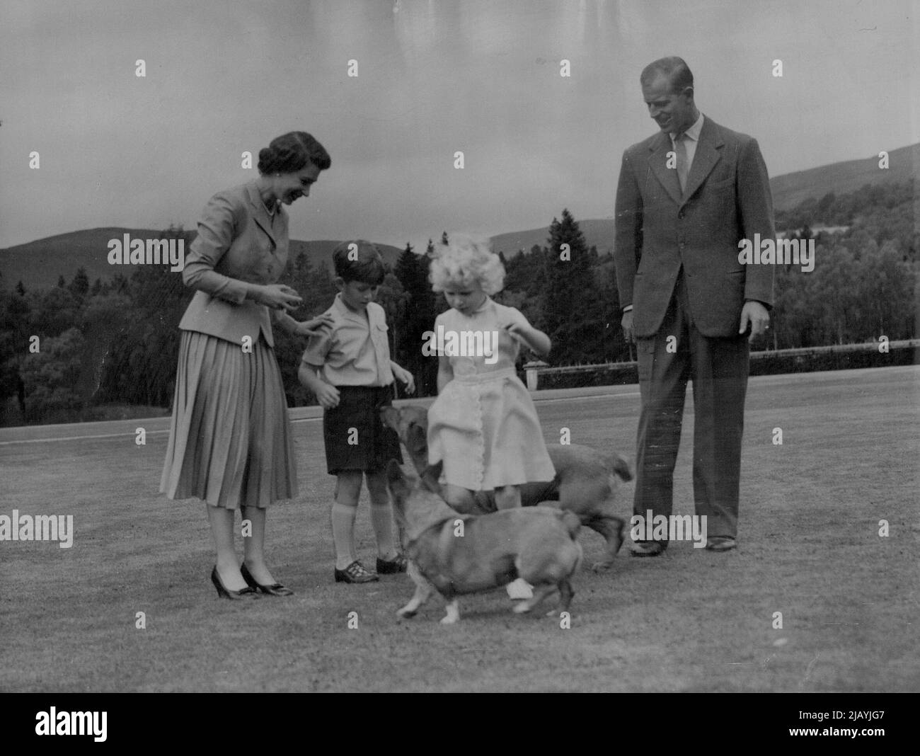 Questo embargo si applica a tutti i paesi della famiglia reale a Balmoral Queen Elizabeth e al Duca di Edimburgo, con i loro figli, il Principe Carlo e la Principessa Anna, Gioca con i Corgi della Regina 'Sugar' (primo piano) e il Duca 'Candy' durante la vacanza estiva della famiglia reale al Castello Balmoral, Scozia. Settembre 26, 1955. (Foto di stampa associata). Foto Stock