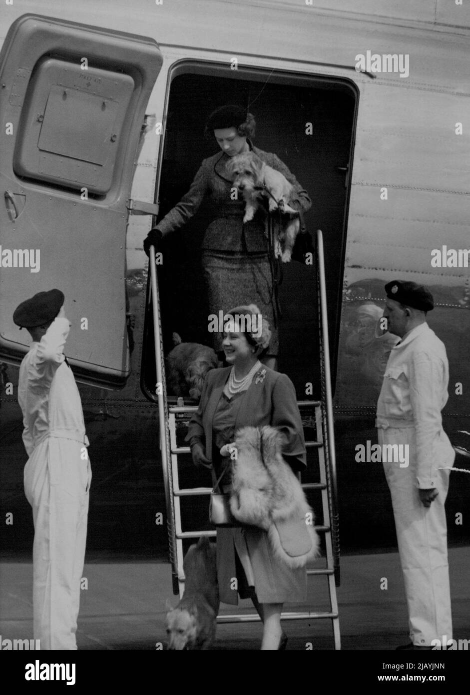 Regina Madre e Principessa di nuovo da Balmoral. La sorridente Regina Madre visto lasciare l'aereo all'aeroporto di Londra dopo aver volato da Balmoral questo pomeriggio. Portando uno dei suoi cani, S.R.H. la Principessa Margaret è vista seguendo la Regina Madre lungo i gradini. S.M. la Regina Elisabetta la Regina Madre e S.R.H. la Principessa Margaret oggi sono tornati a Londra dopo la loro breve vacanza al Balmoral. Maggio 13, 1954. (Foto di Fox Photos). Foto Stock