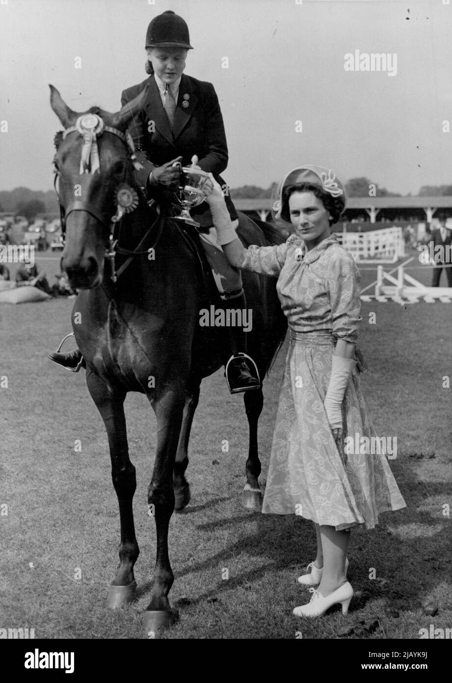Champion Horse -- la duchessa presenta la coppa d'oro per il miglior cavallo allo show di oggi, 'Regina delle onde' guidato da Miss Jane Kent. Questo cavallo ha vinto ***** premi oggi e la coppa d'oro. H.R.H. la duchessa di Gloucester ha visitato il Richmond Horse Show questo pomeriggio, e ha consegnato premi ai vincitori del Premio. Giugno 10, 1948. (Foto di Fox foto) Foto Stock