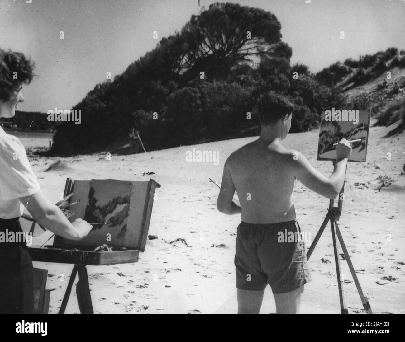 Ottenere una prima estate Tan David Williams di Hawthorn, Melbourne, dipinge in shorts. David che era un Gunner navale sta facendo l'arte commerciale. Studente di campagna di sinistra Loraine Broomfield da Glengarry, Gippsland, Victoria del sud, che consiglio a Melbourne Ourne per frequentare le classi universitarie. Novembre 22, 1947. (Foto di Edmond Russel). Foto Stock