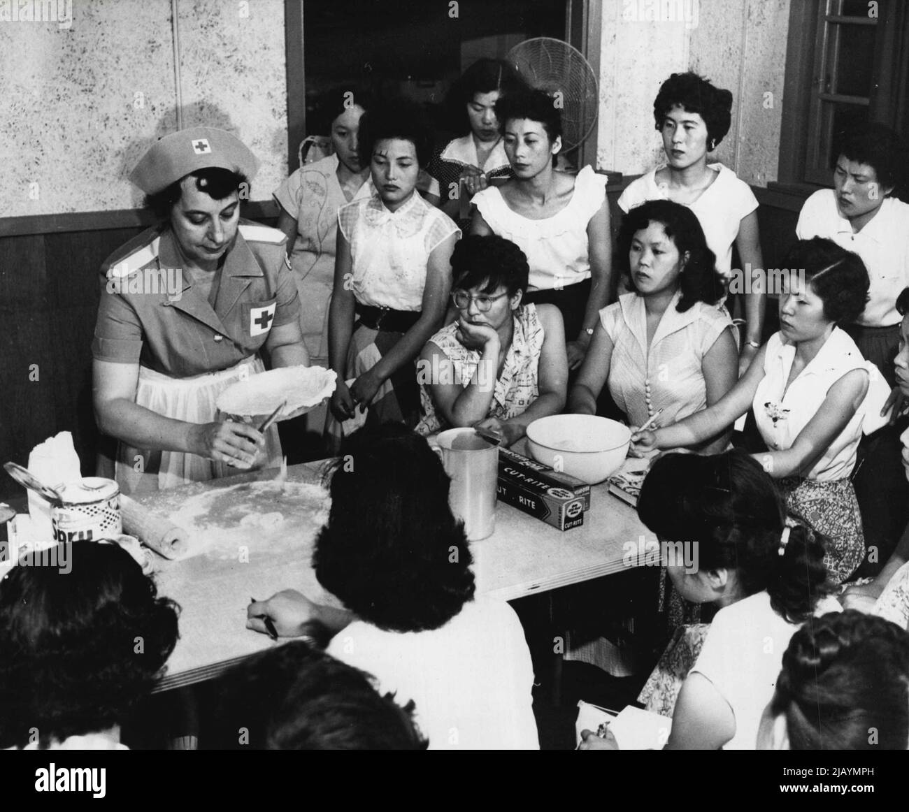 School for Brides - l'arte del Pie-making è dimostrata dagli studenti di Camp Zama dalla signora Macon Fry, di Salem, Messa. Le ragazze hanno sentito molto circa il fuss gli uomini americani fanno sopra 'Mom's Apple Pie'. Dicembre 08, 1955. (Foto di United Press). Foto Stock