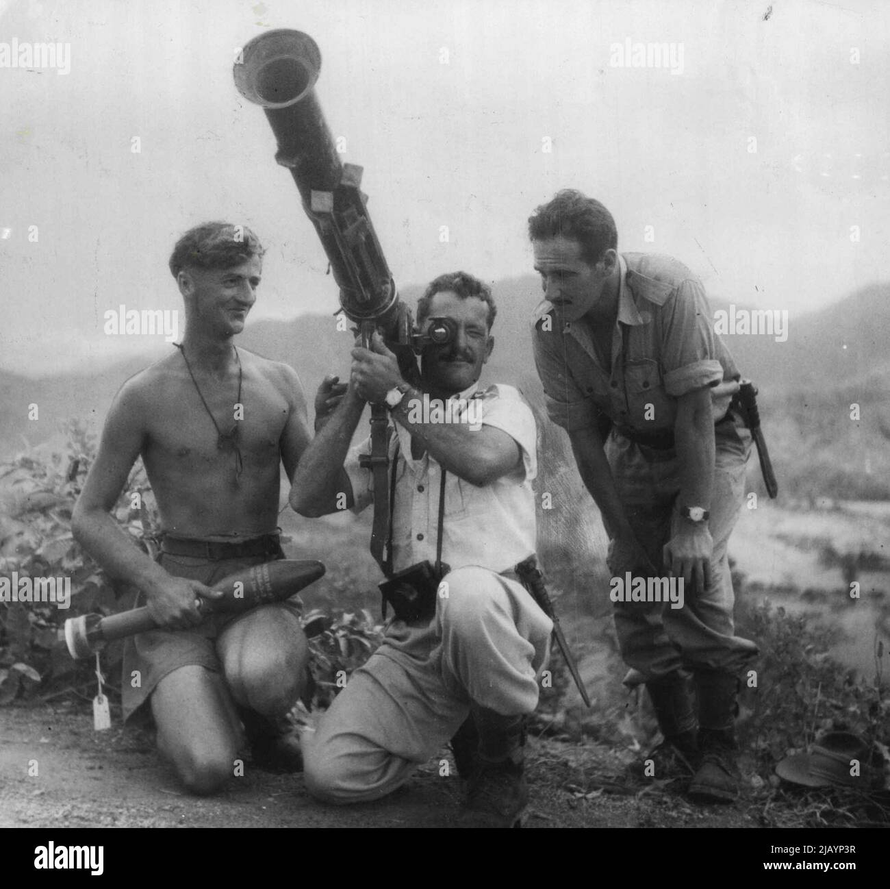 Due piloti Gloucester Meteor Jet dello Squadron australiano 77 hanno recentemente fatto visita alle truppe della 'A' Company australiana per vedere come i 'Diggers' stavano volando in prima linea. Hanno mostrato un certo interesse per la pistola di lancio del razzo di Bazooka in modo che i Diggers hanno permesso loro di sparare. Circa per sparare l'arma è Sgt. Pilota Allan Avery (Newcastle, NSW). Il Digger che lo istruisce è Sgt. VIC Svenson (Belmore, Sydney) e l'altro pilota che guarda è F/Sgt. Bill Middlemiss (Newborough, Vic.). Volando oltre la prima linea, i piloti dei combattenti non vedono troppo della battaglia qui sotto, quindi Gloucester Meteor jet p Foto Stock