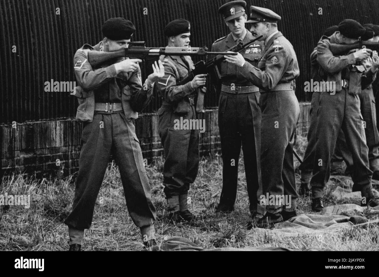 Il Duca di Edimburgo con l'Esercito - H.R.H. il Duca di Edimburgo (guardando la fotocamera) ascolta una descrizione del nuovo fucile F.N. - ora rilasciato all'Esercito britannico, durante la sua visita al Battaglione del 1st il reggimento Wiltshire sulla piana di Salisbury, Wiltshire. Il duca di colonnello - in - Capo del reggimento. Novembre 26, 1954. (Foto di Sport & General Press Agency Limited). Foto Stock