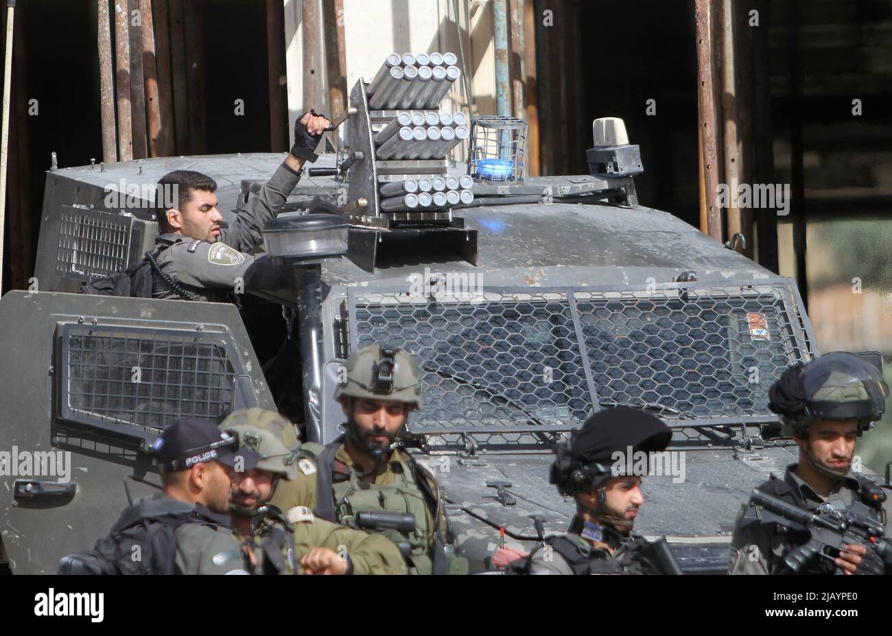 Un soldato israeliano equipaggia un lanciatore di taniche di gas lacrimogeno su un veicolo blindato, proteggendo la strada per prevenire l'attrito tra palestinesi e coloni ebrei nella città di Hawara, a sud di Nablus nella Cisgiordania occupata. Foto Stock