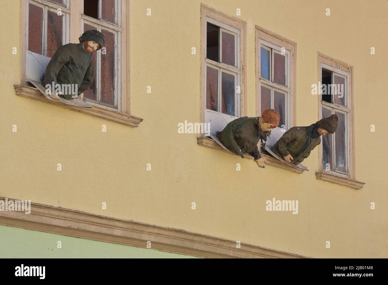 Tre sculture a grandezza naturale che sporgono da una finestra a Mühlhausen, Turingia, Germania Foto Stock