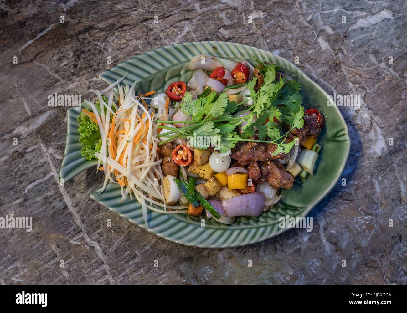Friggere le costolette di maiale fritte e l'aglio sott'aceto, servite con le carote grattugiate e i coriandri di papaie grattugiate. Vista dall'alto, fuoco selettivo. Foto Stock