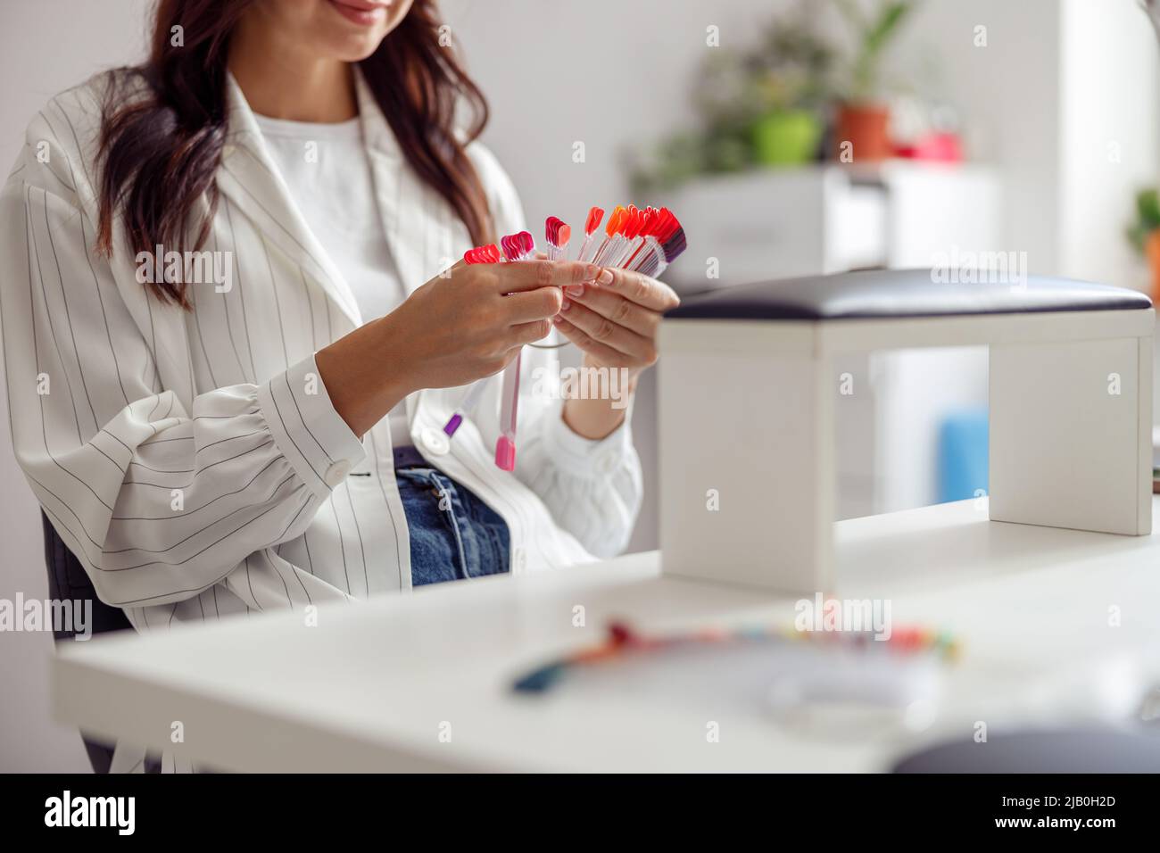 Donna fiduciosa che ha manicure del chiodo nello studio di arte del chiodo Foto Stock