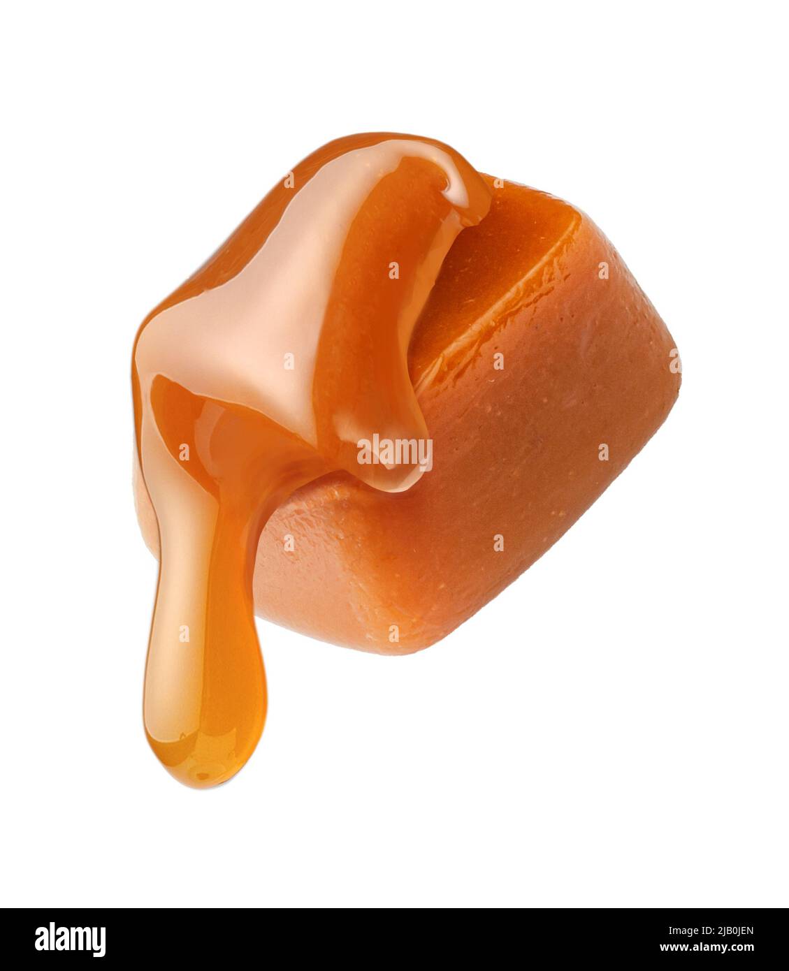 Salsa di caramello che scorre su cubo di caramello isolato su sfondo bianco. Caramella al caramello con caramello liquido. Foto Stock