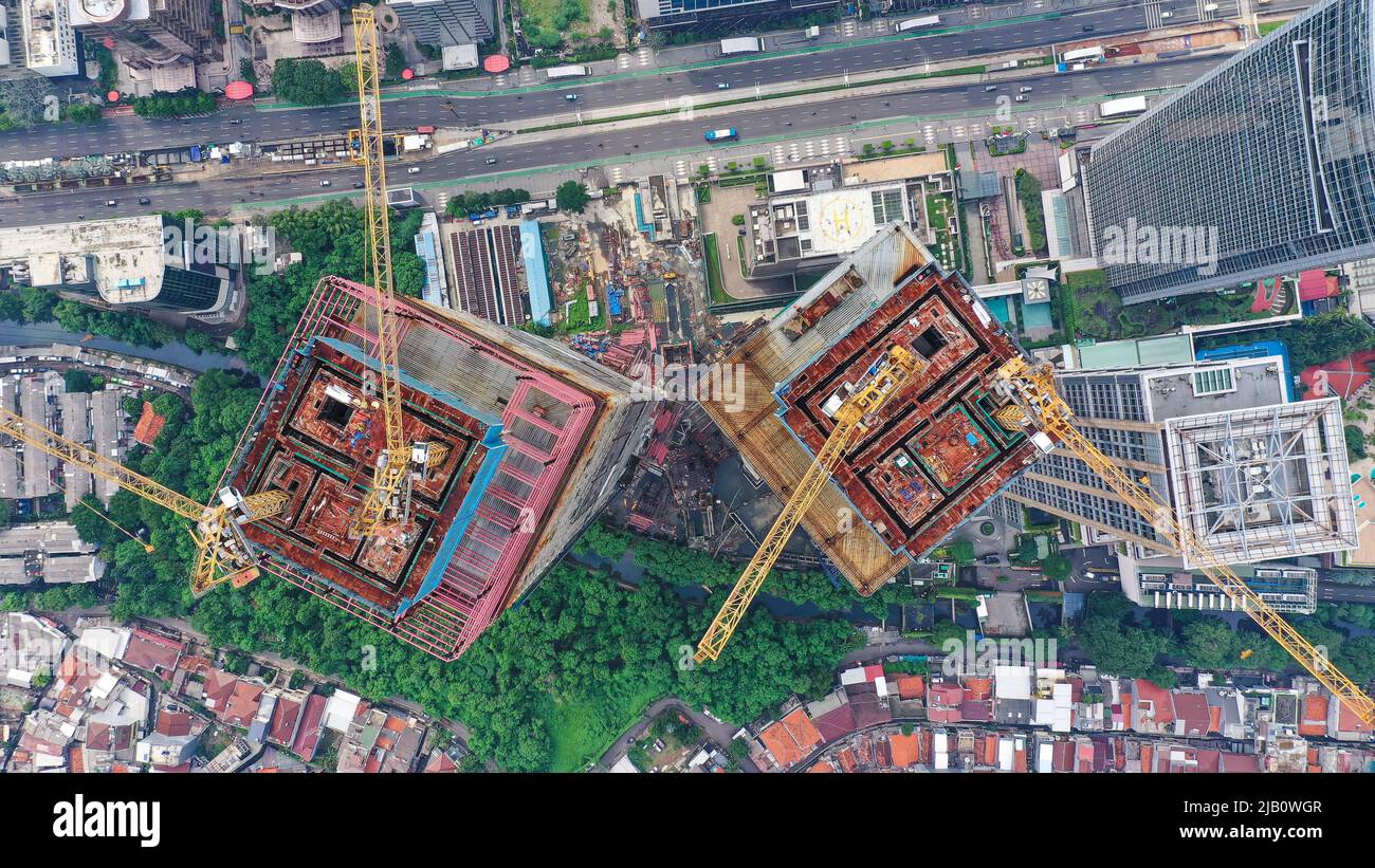 Grattacielo in costruzione nella città di Giacarta. Top Down gru sul tetto di un grattacielo Foto Stock