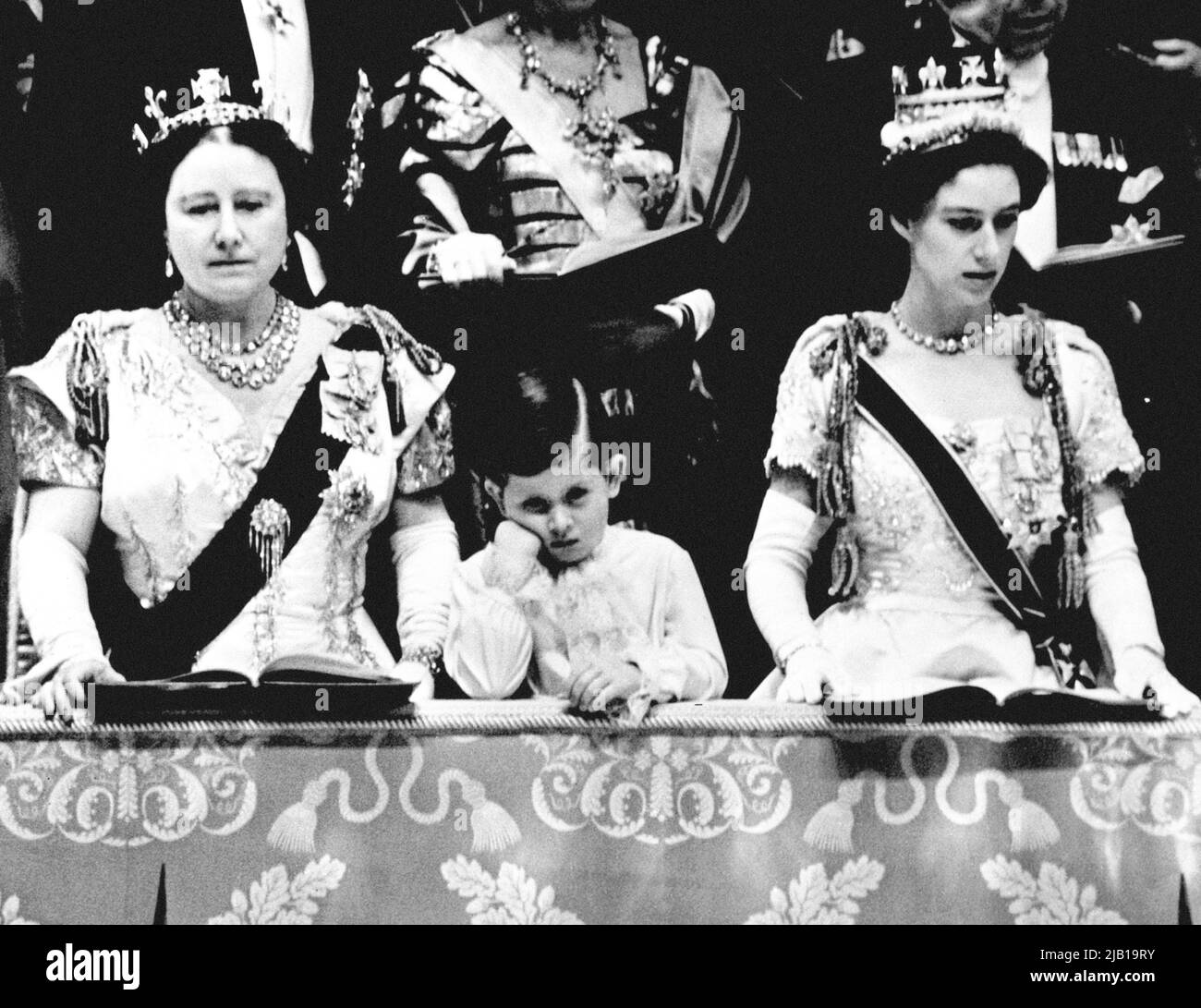 File photo datato 2/6/1953 del Principe Carlo che guarda solenne come si alza in piedi mento a portata di mano tra la Regina Madre e la Principessa Margaret nella scatola reale all'Abbazia di Westminster, da dove vide la Regina incoronata. L'inizio delle celebrazioni giubilari della Regina ricorre in un anniversario significativo per il monarca - la sua Coronazione. Sessantanove anni fa, Elisabetta II fu incoronata in una cerimonia religiosa organizzata il 2 1953 giugno nei dintorni storici dell'Abbazia di Westminster e celebrata con feste di strada in tutto il paese. Data di emissione: Giovedì 2 giugno 2022. Foto Stock