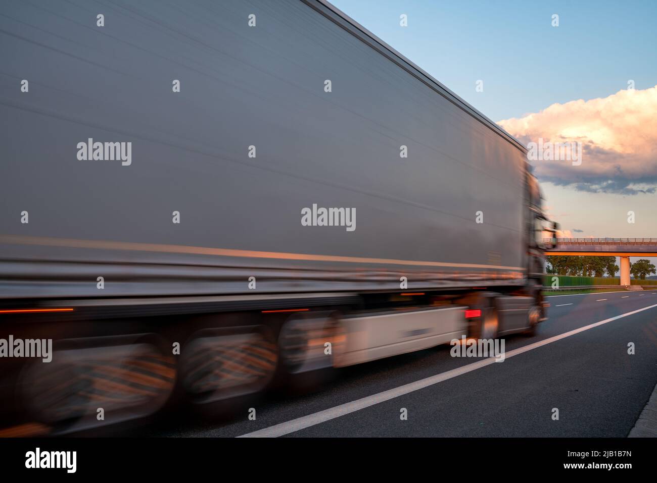 Camion in autostrada durante il tramonto spettacolare, movimento intenzionale sfocatura Foto Stock