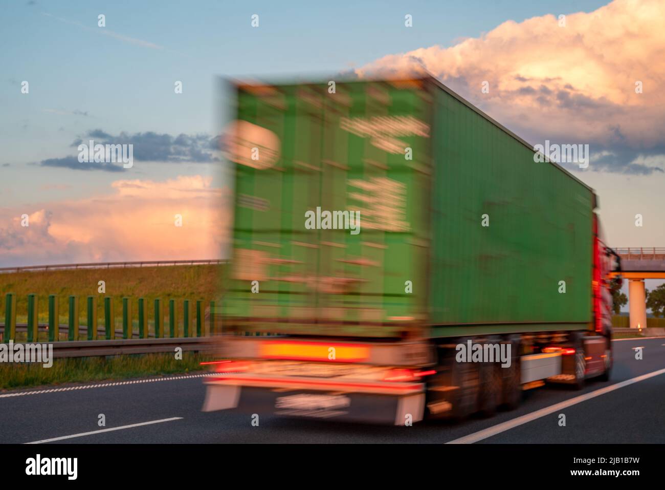 Camion in autostrada durante il tramonto spettacolare, movimento intenzionale sfocatura Foto Stock