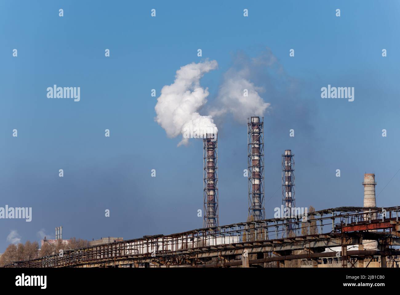 Fumo stack di centrale di carbone su sfondo cielo blu. Foto Stock