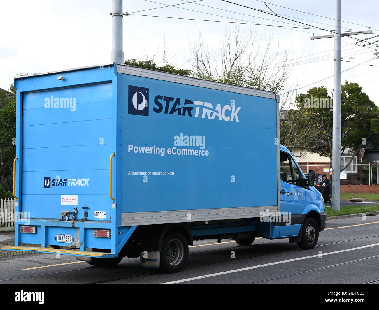 Vista laterale di un camion di consegna StarTrak blu che trasporta merci attraverso la periferia di Melbourne Foto Stock
