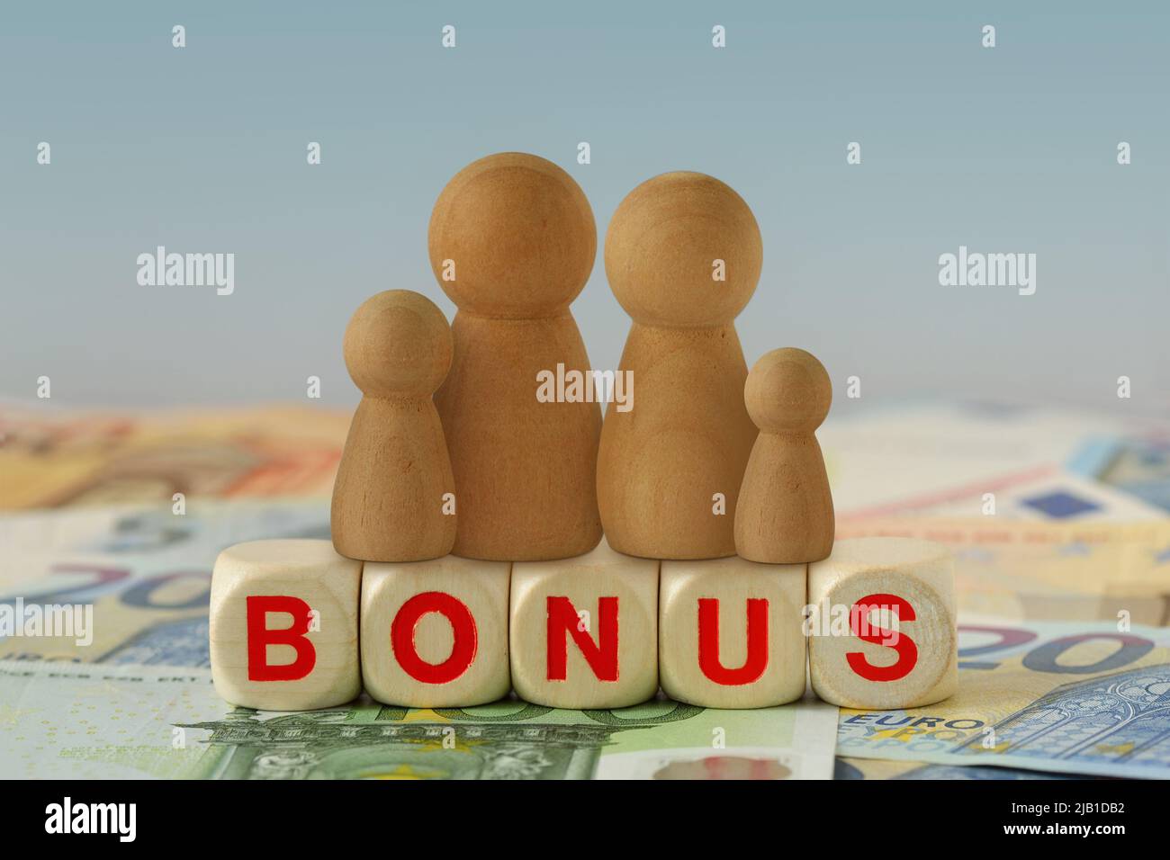 Famiglia su blocchi di legno con la parola Bonus sulle banconote in euro - concetto di bonus economico e di aiuto finanziario Foto Stock