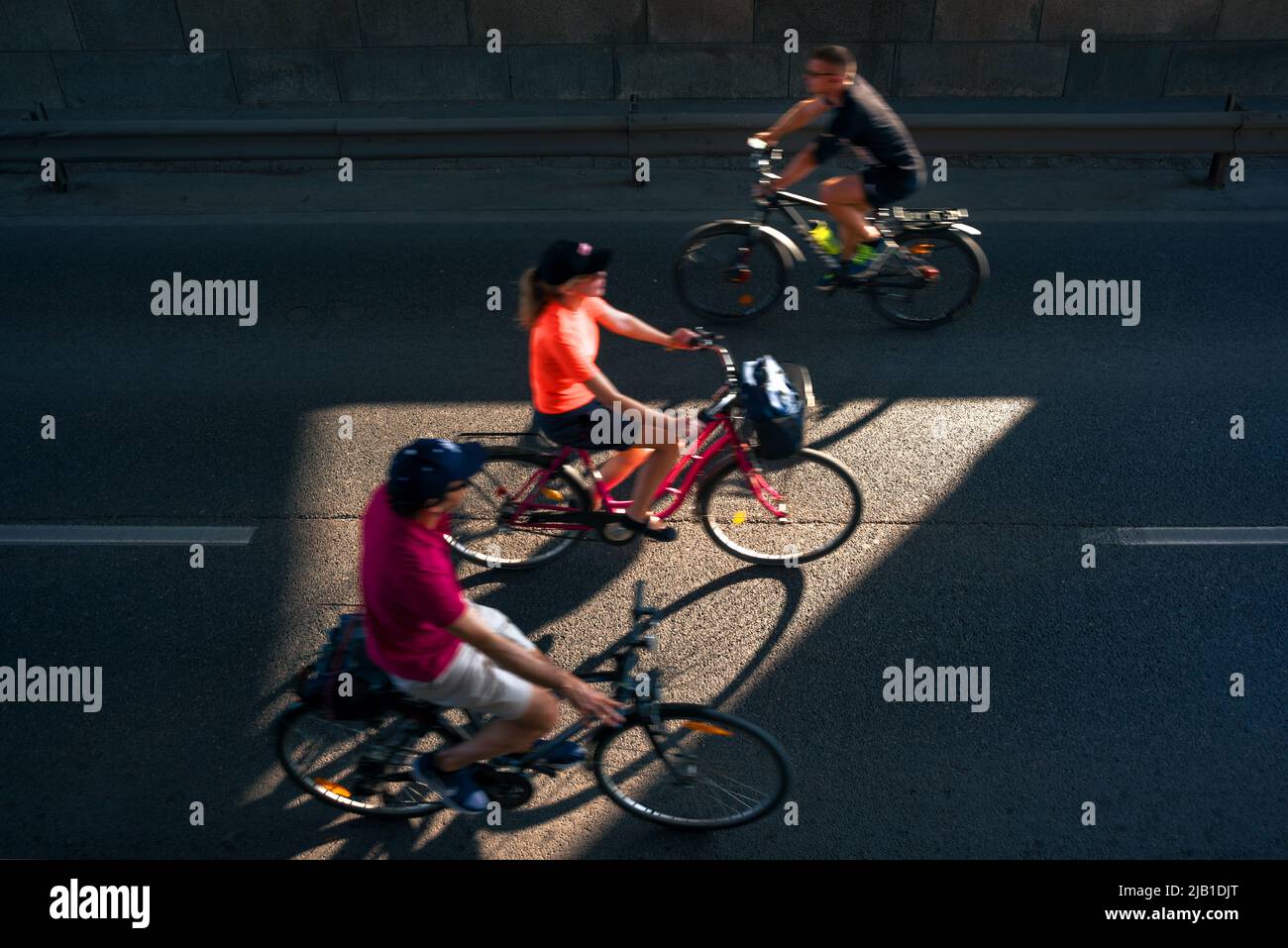 Persone che guidano una bicicletta in città Foto Stock