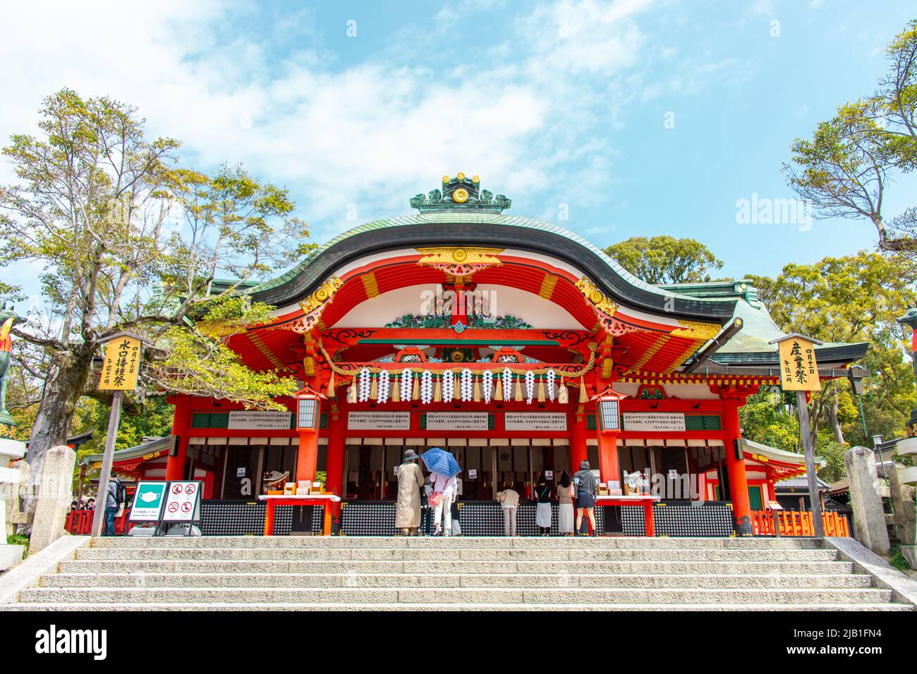 Sala principale "Honden" di Fushimi Inari-taisha in giornata di sole. Si trova alla base di un Inariyama a Fushimi-ku ci sono turisti e preghiere a immagine. Foto Stock