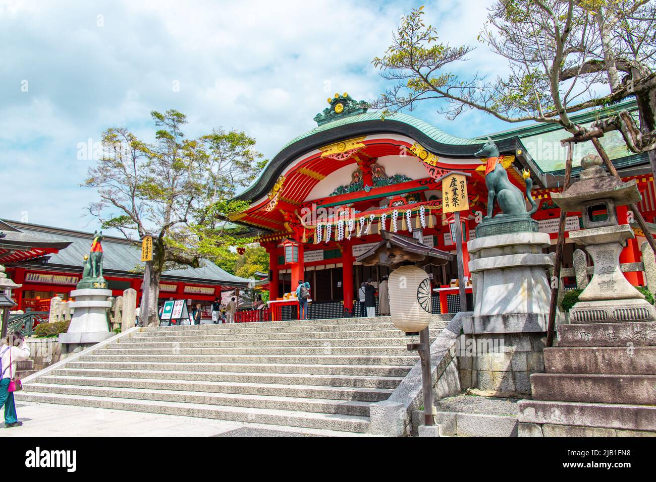 Sala principale "Honden" di Fushimi Inari-taisha in giornata di sole. Si trova alla base di un Inariyama a Fushimi-ku ci sono turisti e preghiere a immagine. Foto Stock