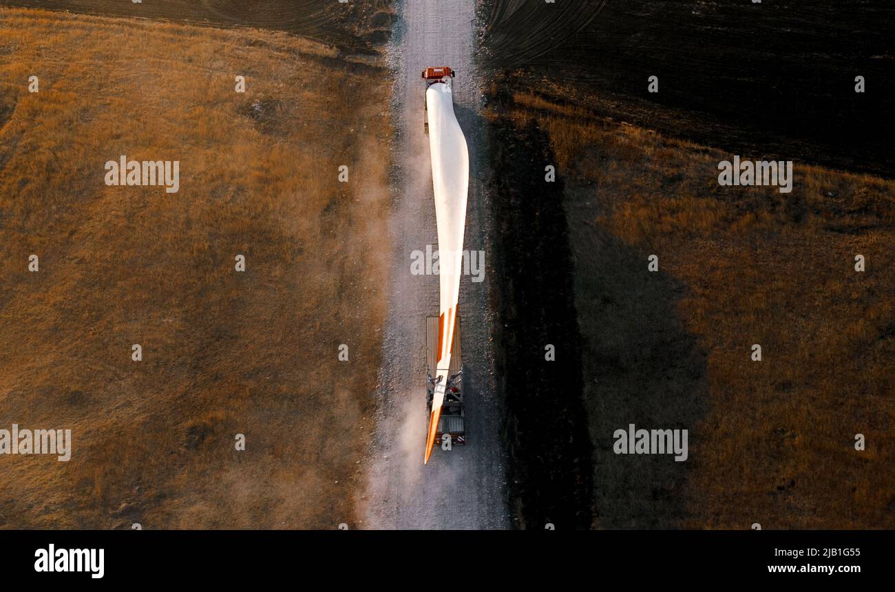 Bladi di turbine per una turbina eolica che viene trasportata nel cantiere tramite camion Foto Stock