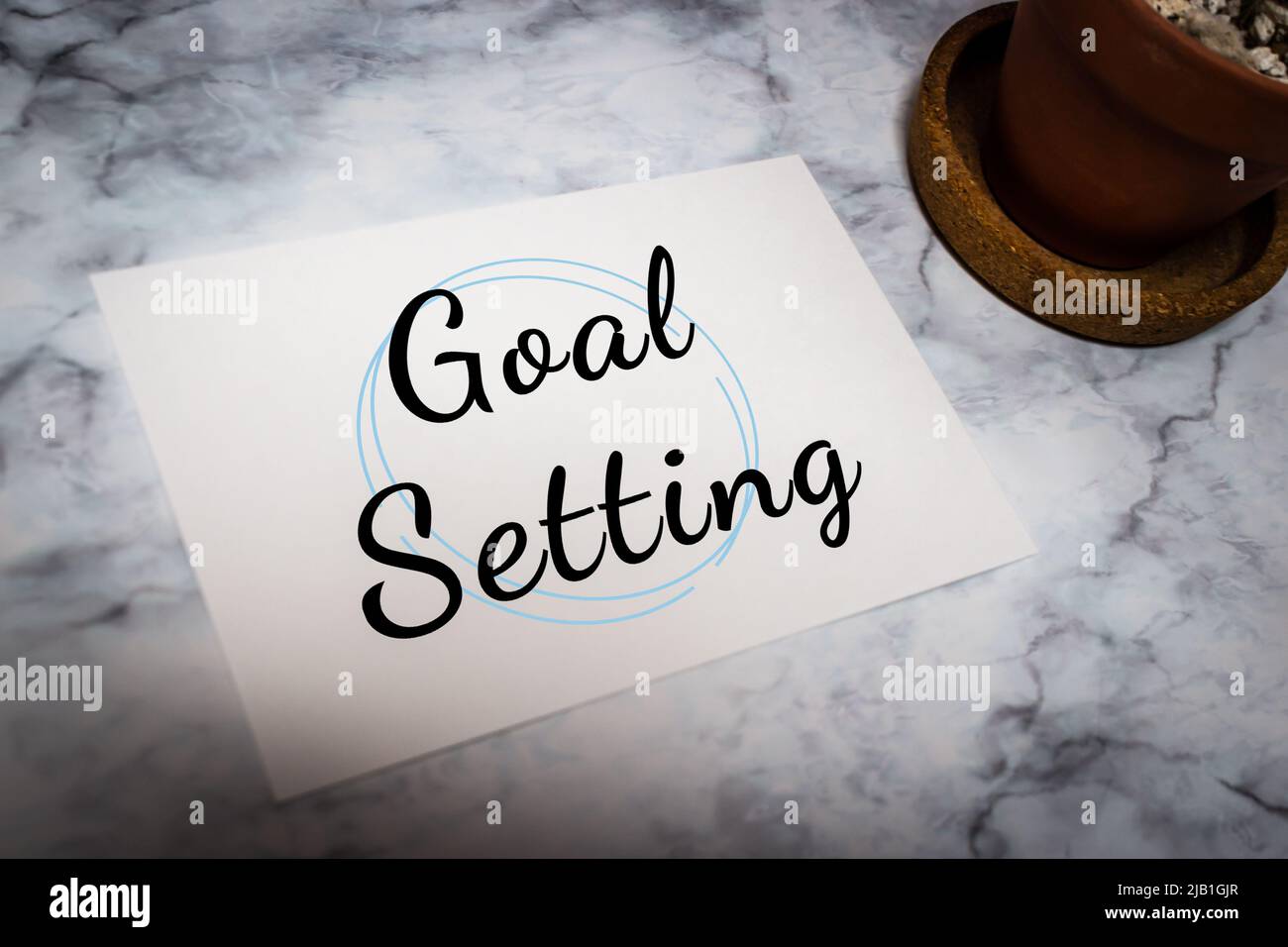 Scrittura scheda messaggio “Goal setting: Su tavolo in marmo bianco con cactus. Azione di definizione di obiettivi personali, attività, business & Work Commitment Concept Foto Stock