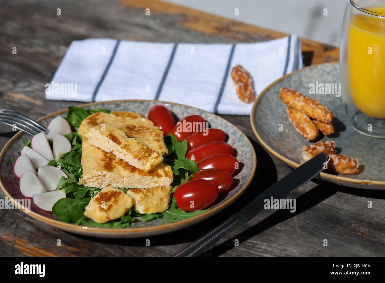 Una colazione leggera di frittata francese con ravanelli, pomodori spinaci e rucola. Colazione europea Foto Stock